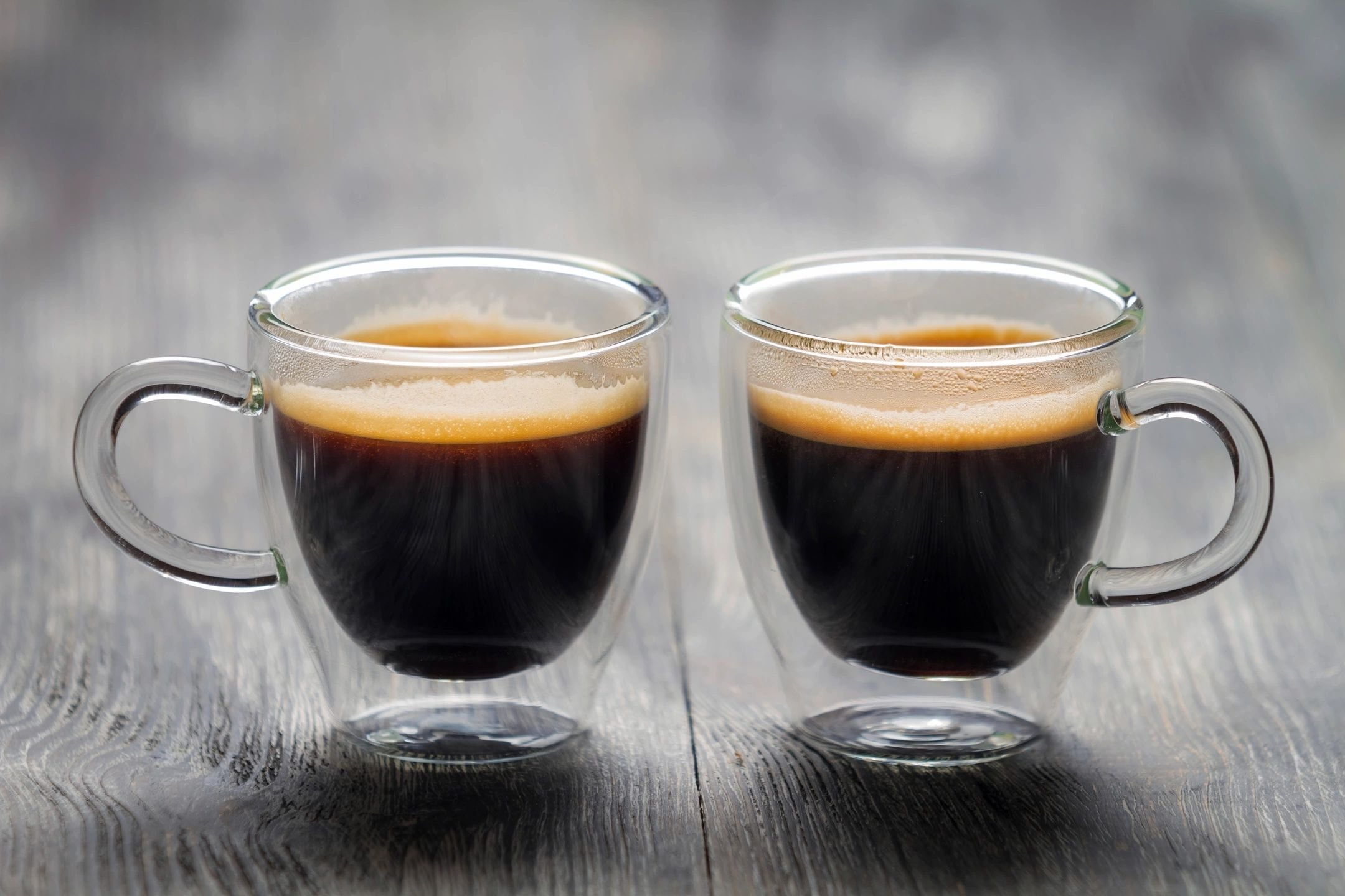 Two espresso cups on wooden surface