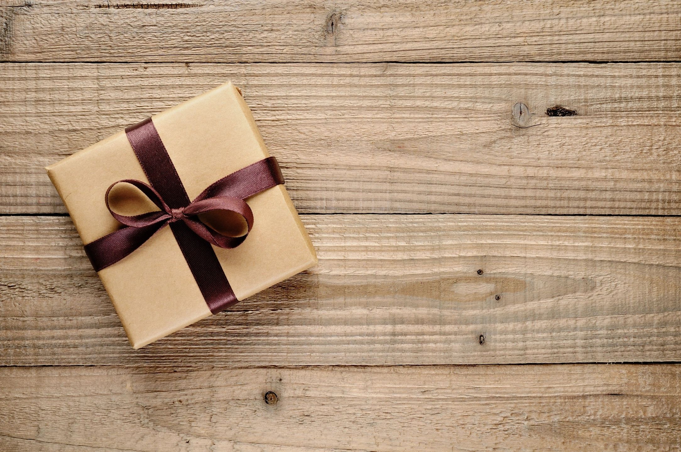 Cream gift box with ribbon on wood